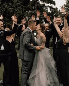 Layer 0 bridal party cheering for couple in wedding photo