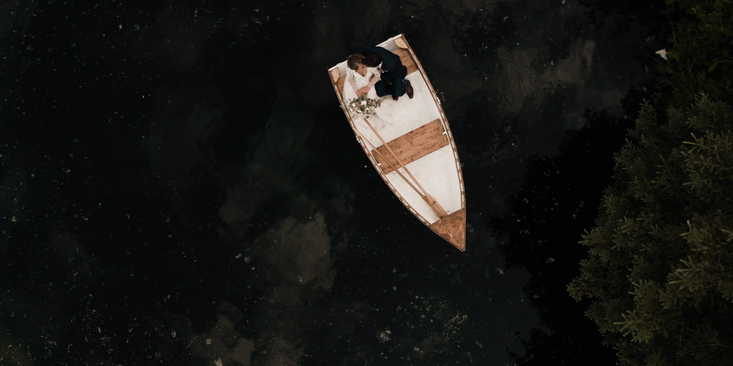 Drone WEDDING photograph of couple sitting on a boat in a pond